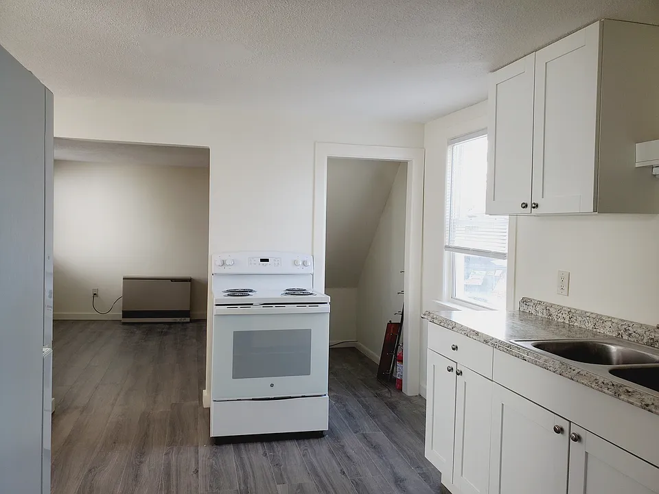 Kitchen with views of living room area, and small storage area