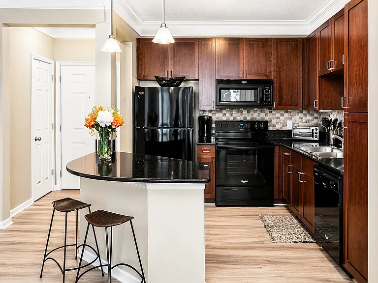 Enjoy bar seating that overlooks a fully equipped kitchen with cherry wood cabinets, glass cooktop stove, built-in microwave, dishwasher, toaster oven, and Keurig coffee maker_perfect for casual dining or entertaining.