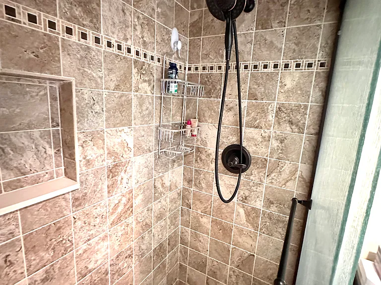 Start your day in luxury. Our primary bath has been beautifully upgraded with elegant tile work and a high-flow shower head. It's the perfect way to wash away the sand after a day at the beach & feel completely refreshed in your own private sanctuary.