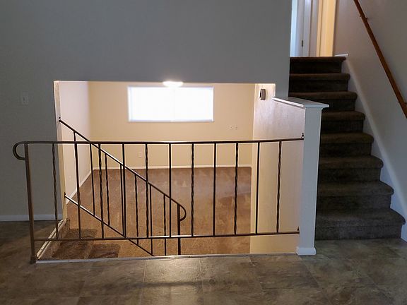 View from living room to lower-level family room and stairs to upper-level