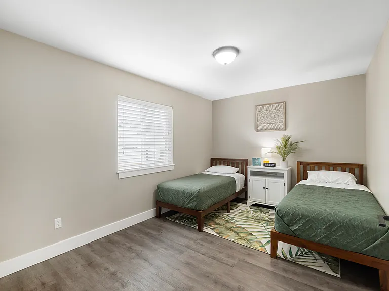 Bedroom #2 - 2 twin beds with a closet across the room that includes cubby storage and an assortment of kids books and toys