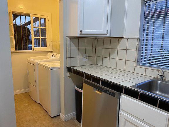 Kitchen with laundry nook. Freshly painted cabinets and Brand new dishwasher