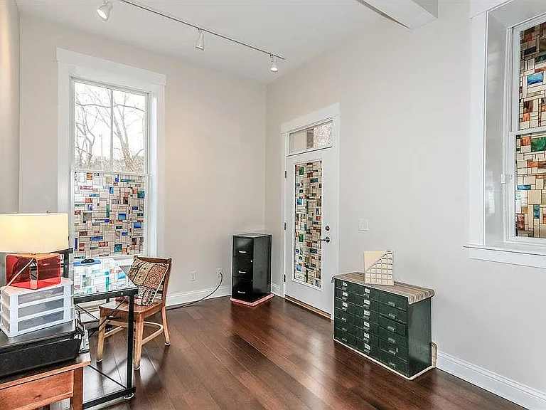 Second bedroom with hardwood floors and partially covered walk out deck with river view.