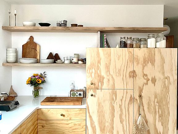 custom kitchen with hidden appliances and shelves made from local sweet gun trees.