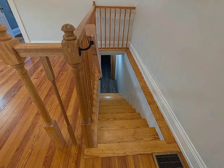 Freshly refinished wooden steps lead to finished basement