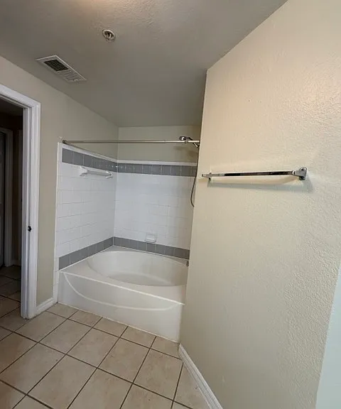 Bathroom 1 includes a spacious bathtub and shower. Located just to the left of the entry, it also connects to the bedroom beyond, creating a private suite-like area.
