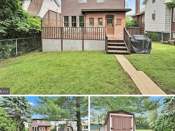 Gated backyard including back deck and shed.