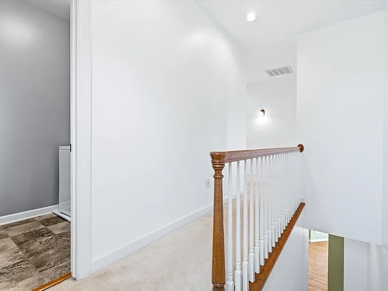 Secondary staircase to kitchen showing access to laundry room and bedrooms