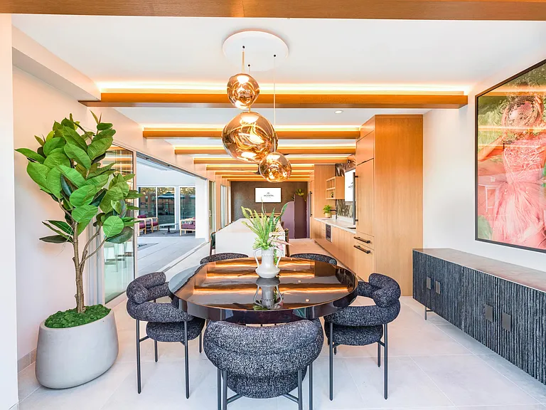 An expansive rooftop clubroom features a demonstration kitchen and gathering spaces that open directly to the rooftop deck.