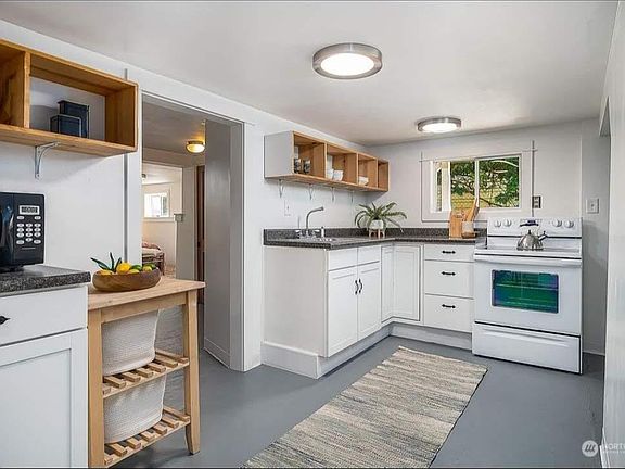 Kitchen complete with range, microwave, large sink, refrigerator, and washer/dryer.