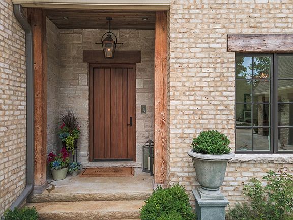 The 8 ft mahogany door sheltered by the front porch greets guests with such a cozy welcome.  And ela