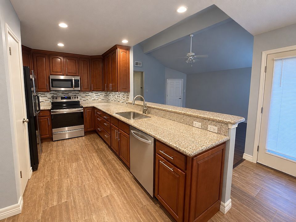 Open galley style kitchen layout with granite countertops, 42" cabinetry, pantry + tons of storage + hidden garbage and recycling pullout!