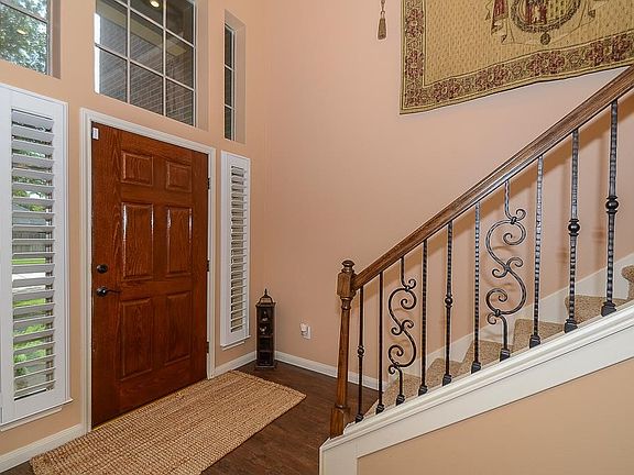 Warm entry welcomes you home with open arms! Elegant wrought iron spindles on staircase.