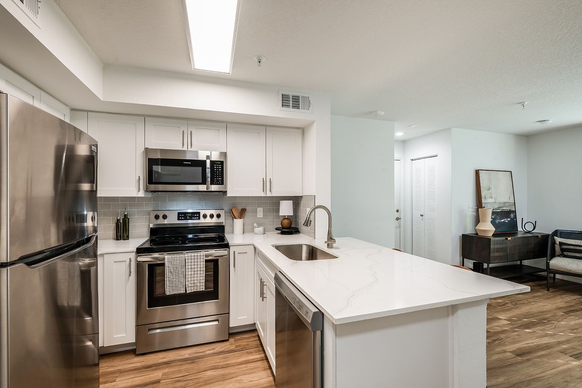 Quartz countertops with breakfast bar, dishwasher, & disposal