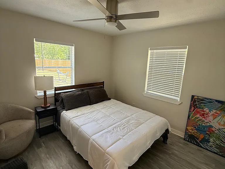 Cozy private room with hardwood-style floors, ceiling fan, and tasteful decor