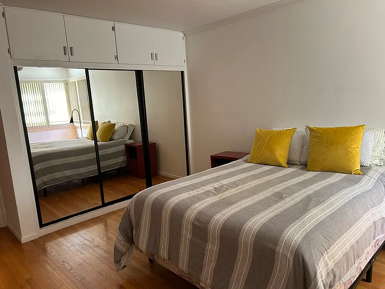 Bedroom one with mirrored closets and storage above.