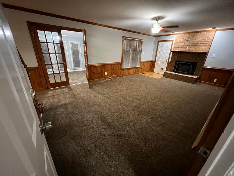 Photo of the family room from front entry way, pictured in the left of the photo is the florida room and door to the 2 car garage to the left of the gas fireplace