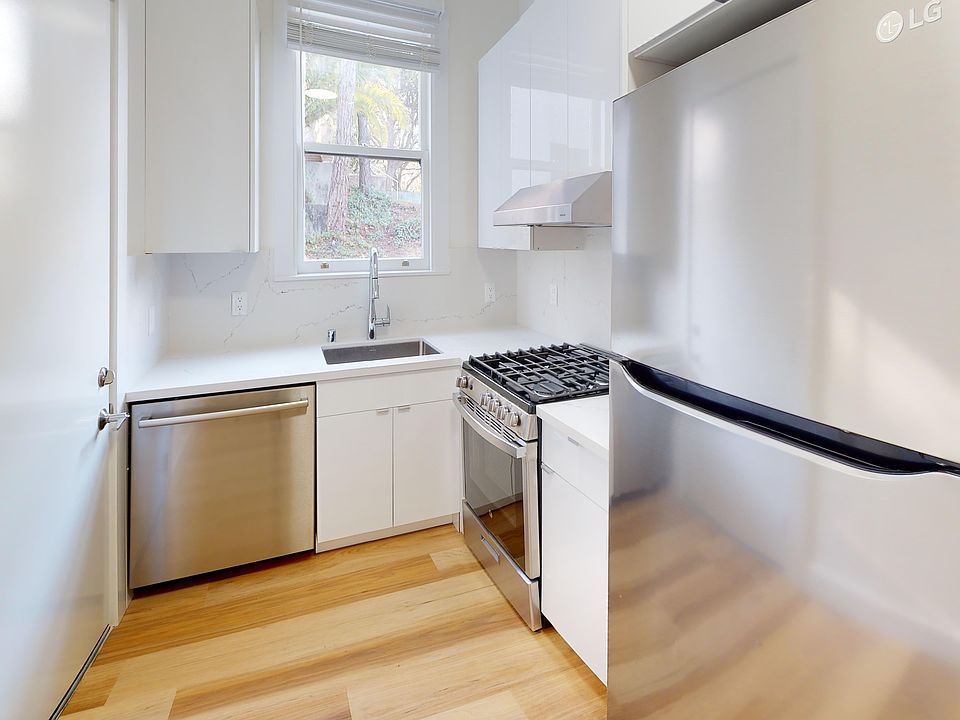 Kitchen with cabinets, refrigerator, stove, range hood, and sink