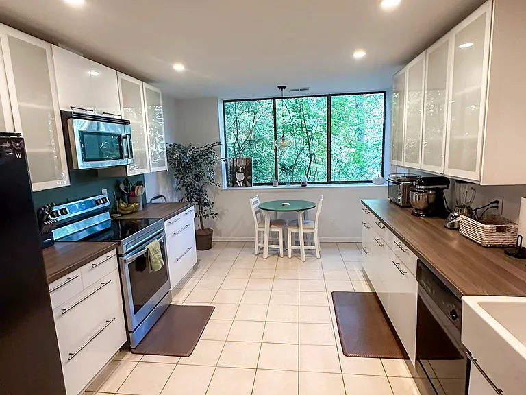 Contemporary kitchen with plentiful high-gloss cabinetry includes electric oven with air-fryer mode; refrigerator; dishwasher; microwave; and garbage disposal. Dedicated pantry and separate laundry room one step away!
