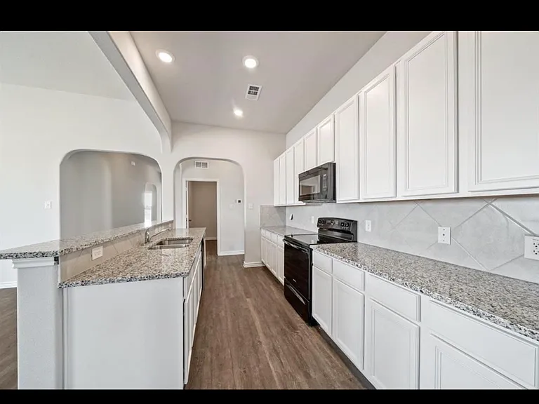 Galley kitchen with oven, microwave, and dishwasher