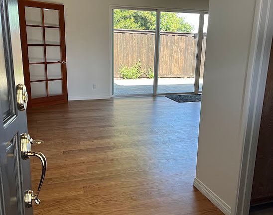 view of living room from front door, kitchen to right