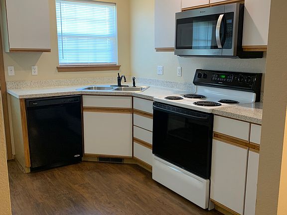 Right side of kitchen, corner sink, lots of light from window over looking back yard, dishwasher, stove microwave