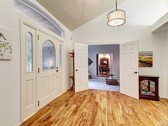 Entry features Acacia hardwood floors and vaulted ceiling. French doors lead to a sunken den/ sitting room which passes through to the formal dining room.