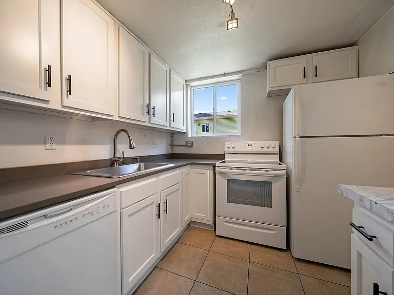 Updated kitchen with newer cabinets and quartz countertops. Window to backyard. Extra drawer storage and eating space or desk or extra counter space to the right