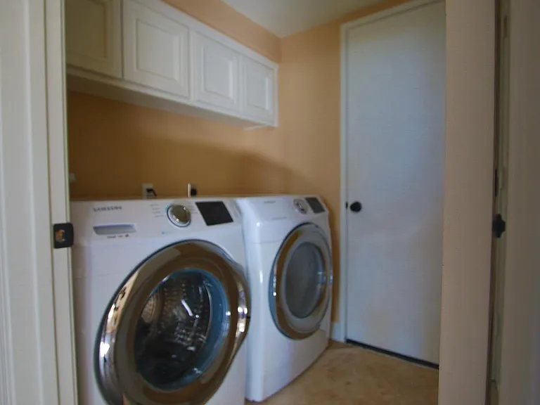 Laundry room with travertine floors and access to garage