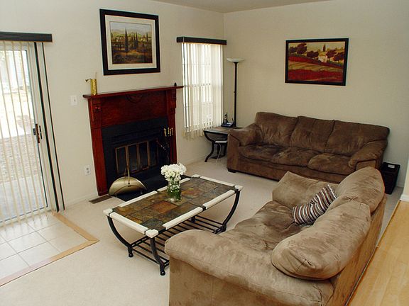 Living room features wood-burning fireplace and sliders to patio