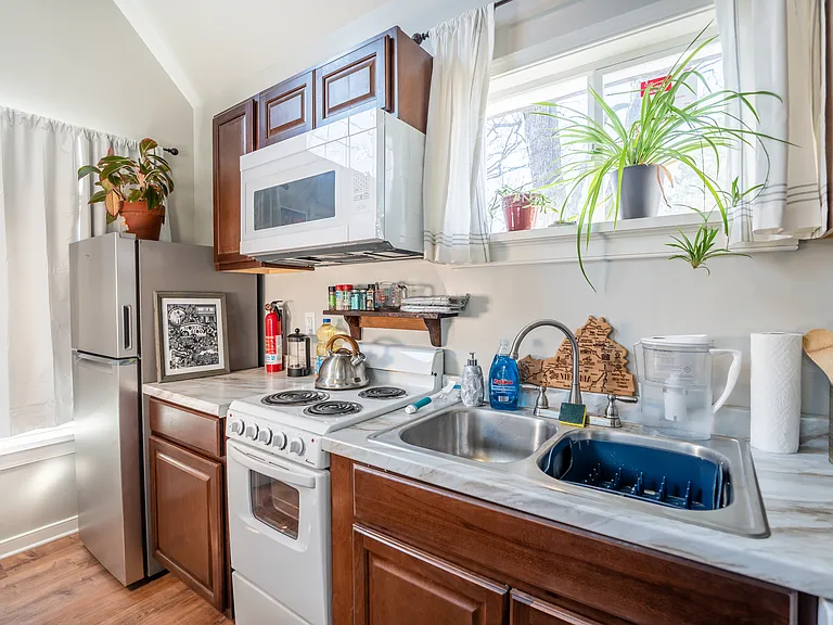 The kitchen is fully equipped, with a large fridge/freezer, four-burner stove and oven, overhead microwave, dishwasher, and double sink