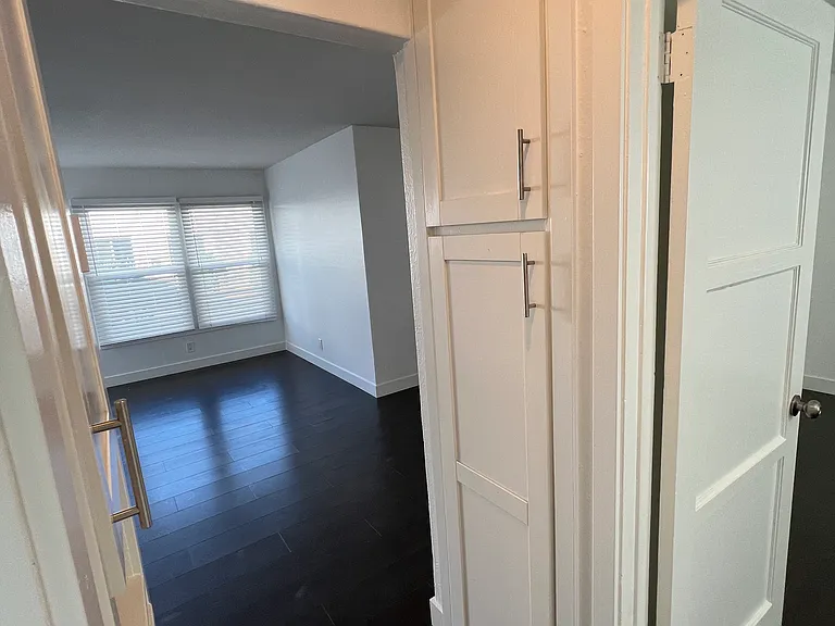 View toward living area from hallway between bedroom and bathroom - more storage