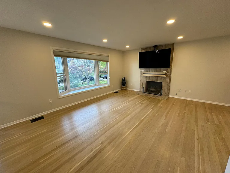 Upstairs living room with fireplace and ceiling tv mount.