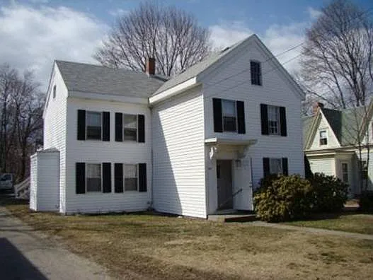 House with driveway to left and parking in rear