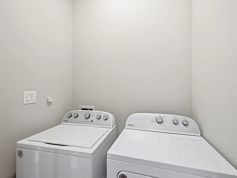 Full-sized washer and dryer located off kitchen.