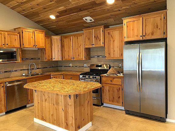 Gas Range, Stainless appliances. Pantry to the right of the refrigerator