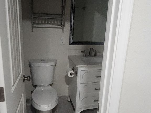 Bathroom: shows modern environmental friendly toilet and vanity cabinet with wash basin and mirror