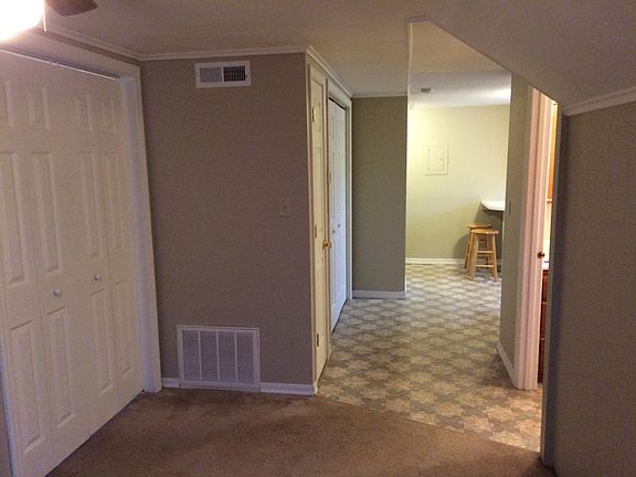 View from the spacious living room. Bedroom doors are shown to the left, bathroom to the right.