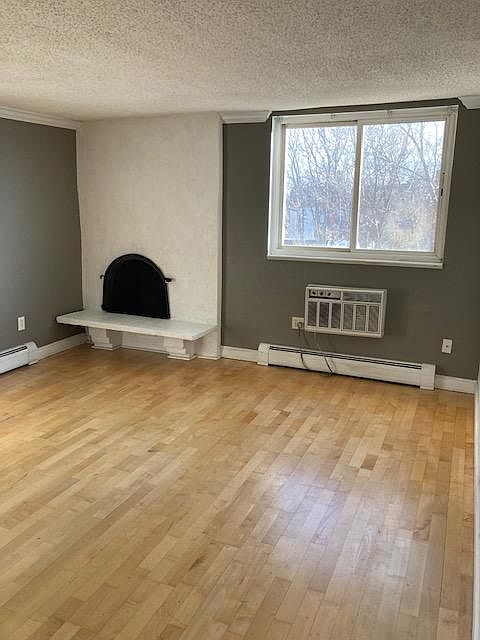 Living room with wood burning fireplace and AC.