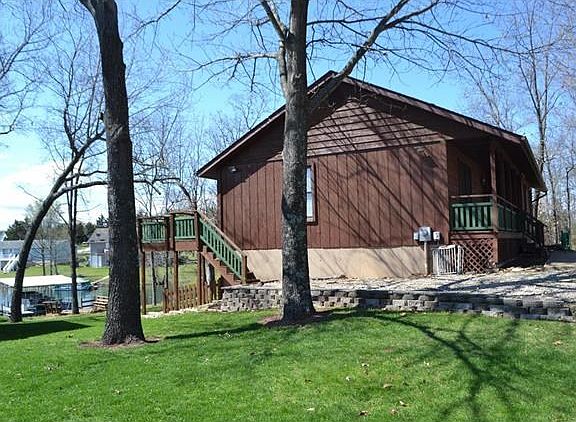 Side exterior showing deck access to rear of home and boat dock.