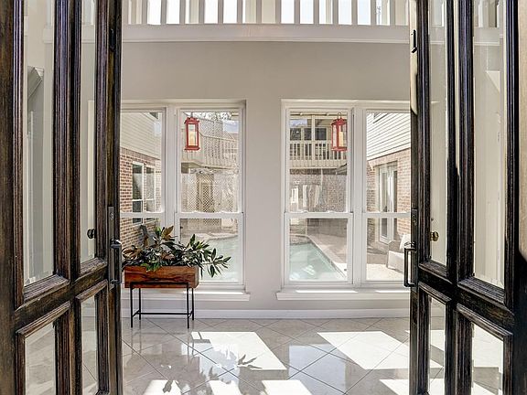 Your eyes are immediately drawn to the sparking blue pool upon entry through the large wood doors with beveled glass panes.