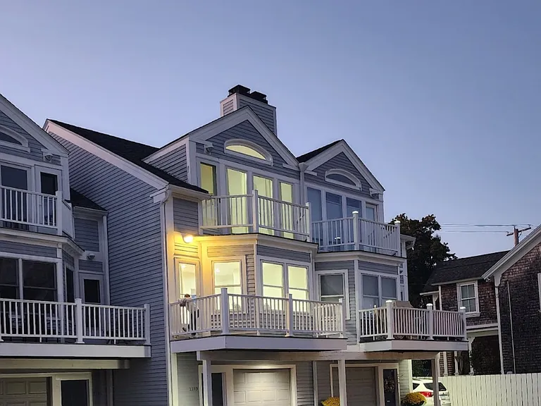 Beautiful exterior at dusk showcasing warm lighting and inviting coastal charm.