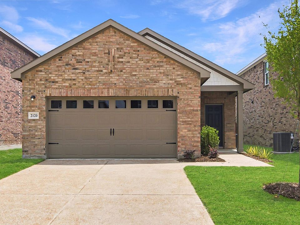 Front exterior featuring brick facade and an attached two-car garage