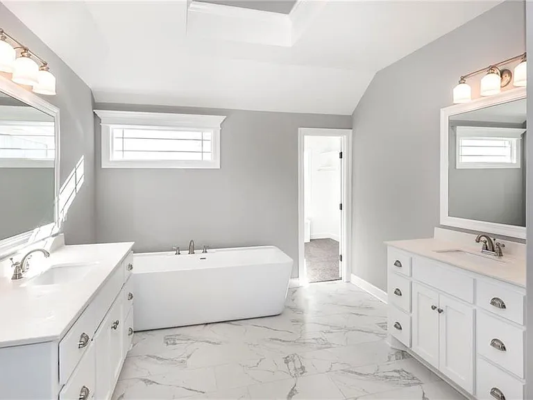 Master bathroom with separate vanities and free-standing soaker tub