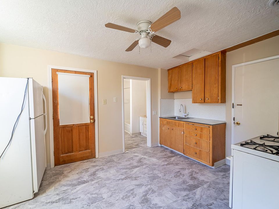 Kitchen with new vinyl, new plumbing, entrance to bathroom.