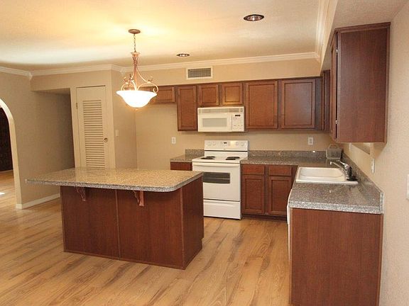 Granite countertops and kitchen island open to living room
