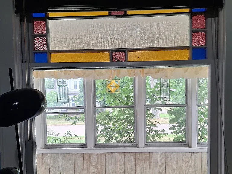original 1900 stained glass window in living room looks out onto front porch