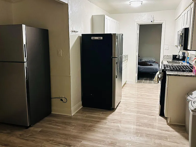 Efficient galley kitchen with generous cabinet storage, granite-look counters, and full-size stainless appliances.