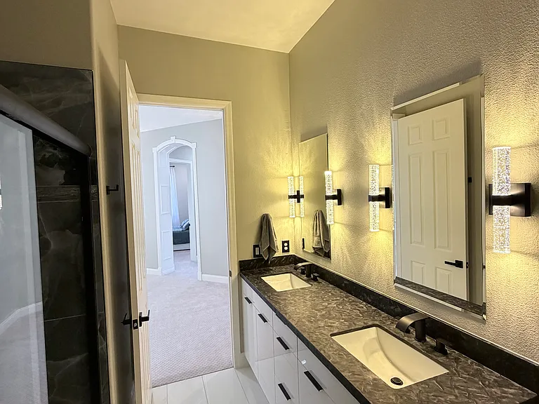 Loft-area bathroom featuring a dual-sink vanity with granite countertops and elegant fixtures