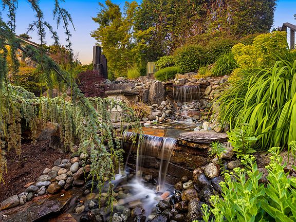 Dramatic yet tranquil waterfall feature greets you as you meander down to the front doors